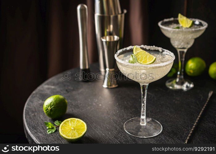 Margarita cocktail with lime and ice on dark wooden table with copy space. Classic Margarita and Daiquiri Cocktail.. Margarita cocktail with lime