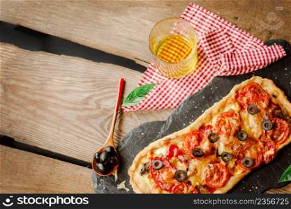 Margarita pizza with mushrooms, mozzarella cheese and cherry tomatoes. Empty place for text.. Homemade pizza on a wooden background