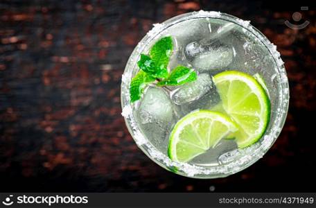 Margarita with mint and ice cubes. Against a dark background. High quality photo. Margarita with mint and ice cubes.