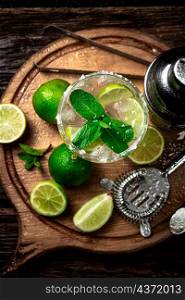 Margarita with pieces of lime. On a wooden background. High quality photo. Margarita with pieces of lime.