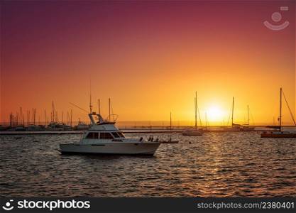 Marina at sunset, one small white yacht on foreground, La Paz, Mexico