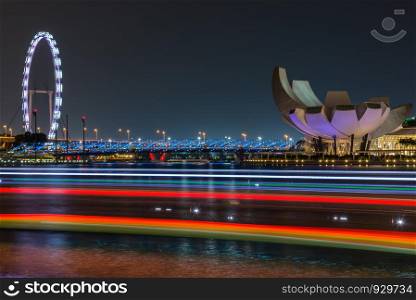Marina bay sands buildings and Singapore flyer with light strip from the travel boat.