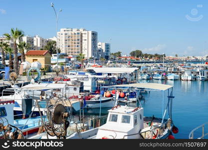 Marina with yachts and cityscape of Larnaca with waterfront apartments in bright sunshine, Cyprus