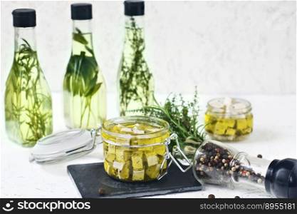 Marinated feta in a glass jar, spices and flavored olive oil on a wooden background.. Marinated feta in a glass jar, spices and flavored olive oil on a wooden background