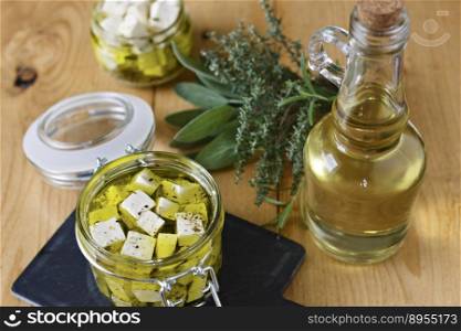 Marinated feta in a glass jar, spices and olive oil on a wooden background.. Marinated feta in a glass jar, spices and olive oil on a wooden background