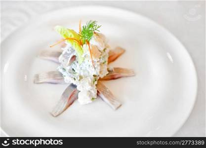 Marinated herring fillets on a white plate