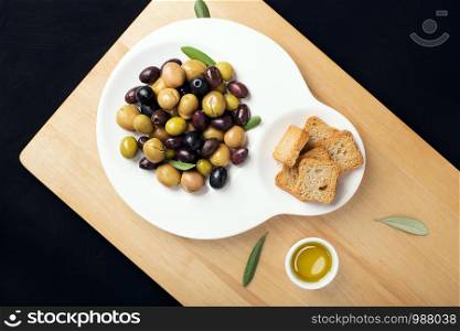 Marinated olives in fashion plate. Tasty mediterranean food. Spanish tapa