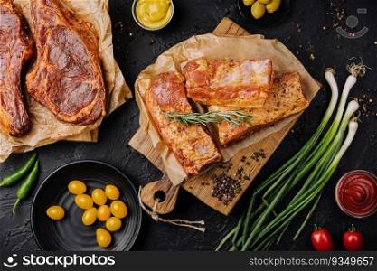Marinated pork steaks on cutting board and ingredients for cooking