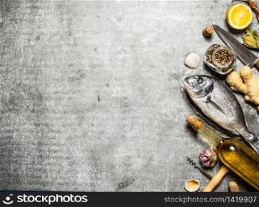 Marine fish with wine and a variety of spices and herbs. On a stone background. Marine fish with wine