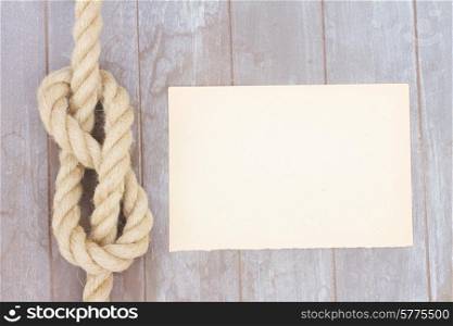 marine knot on wooden background with copy space on paper note. marine knot