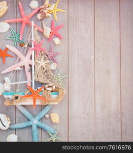 Marine life with seashells, starfish and boat on wooden planks with copy space, retro toned. starfish and boat