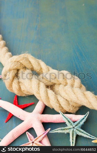 marine rope with starfish on blue wooden background with copy space. marine rope with starfish