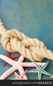 marine rope with starfish on blue wooden background with copy space. marine rope with starfish