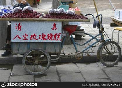 Market vendor selling plums at the roadside, Xi&acute;an, Shaanxi Province, China