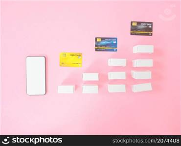 Marketing strategy or loan concepts from smartphone with blank screen and product box on pink background. Top view