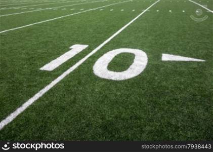 Markings for the ten yard line on an American football field indicate the distance to the goal line.