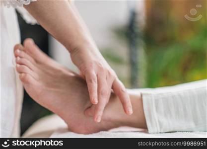 Marma Ankle Therapy. Close up image of Ayurveda practitioner hands treating patient Gulpha Marma. Acupressure points for ankle pain. . Marma Therapy. Ayurveda Ankle Treatment  Gulpha Marma 