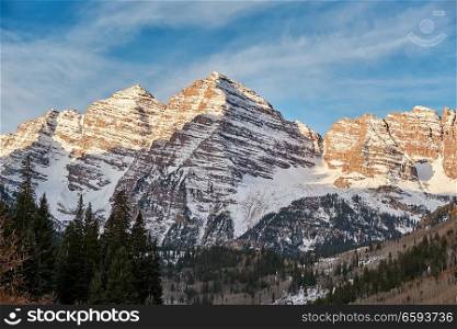 Maroon Bells mountains in snow at sunrise in Colorado Rocky Mountains, USA. 