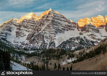 Maroon Bells mountains in snow at sunrise in Colorado, USA.