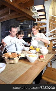 married couple and daughter having breakfast together