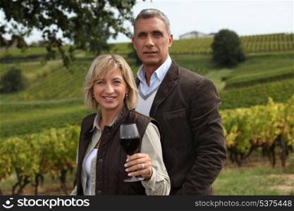 Married couple in vineyard sampling wine