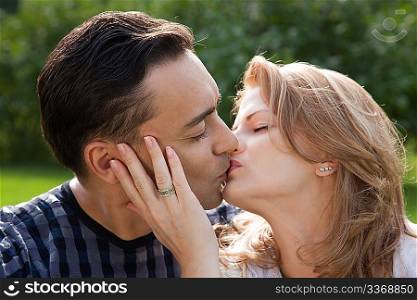 married couple kissing outdoors