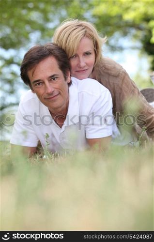 Married couple laying in a field