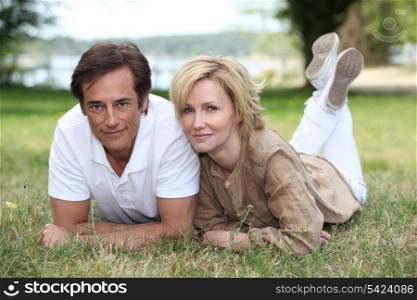 Married couple laying in the grass