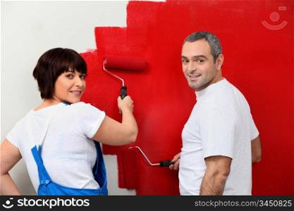 Married couple painting wall