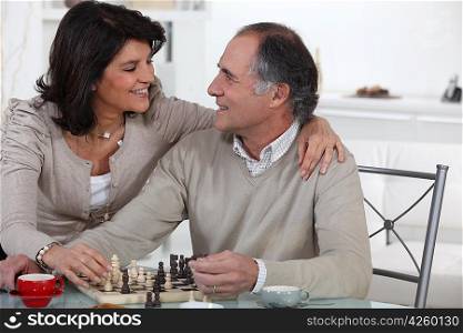 Married couple playing chess at home