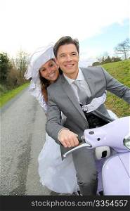 Married couple riding motorcycle on their wedding day