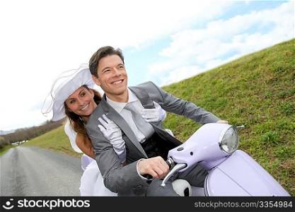 Married couple riding motorcycle on their wedding day