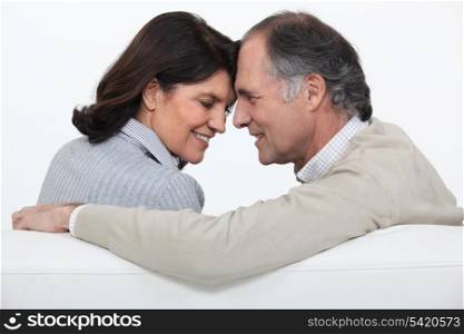 Married couple sat face to face on sofa