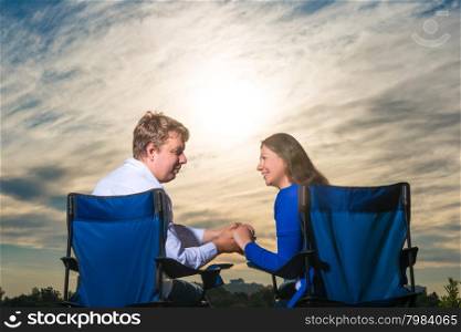 married couple sitting in chairs at dawn