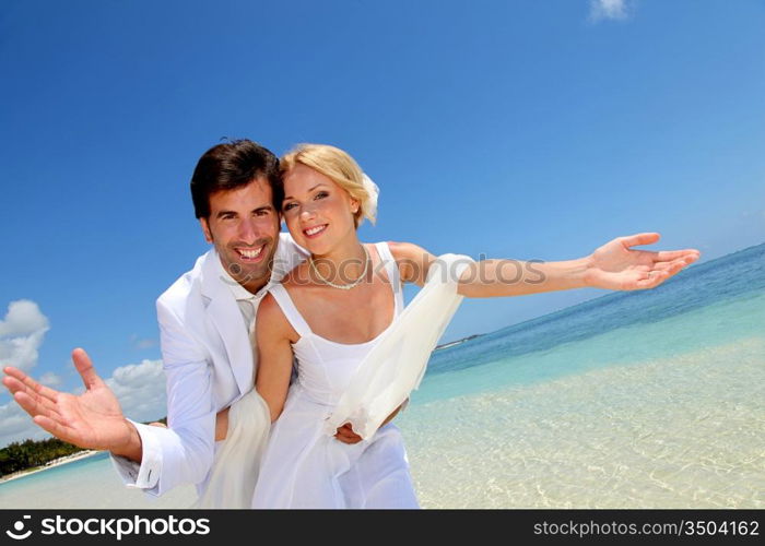 Married couple standing by blue lagoon