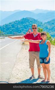 married young couple hitchhiking summer day