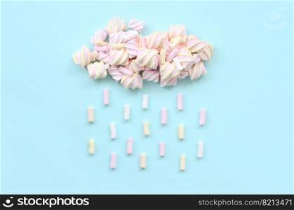 Marshmallow rain cloud on pastel light blue background. Cute metaphorical bad weather concept. Minimal flat lay top view. Marshmallow rain cloud. Cute metaphorical weather concept