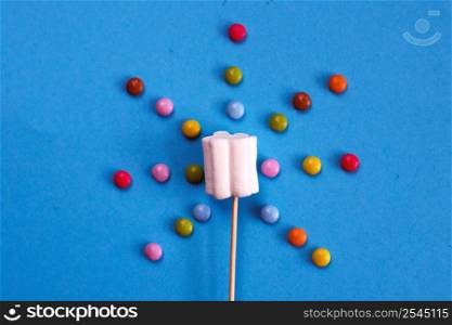 marshmallows composition on wooden skewers on a blue background. Flat lay, holiday concept. sun-shaped sweets. marshmallows composition on wooden skewers on blue background. Flat lay, holiday concept. sun-shaped sweets