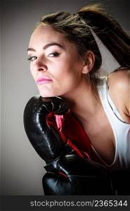 Martial arts or self defence concept. Sport boxer woman in black gloves. Fitness girl training kick boxing.