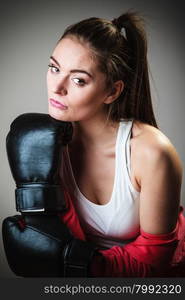 Martial arts or self defence concept. Sport boxer woman in black gloves. Fitness girl training kick boxing.