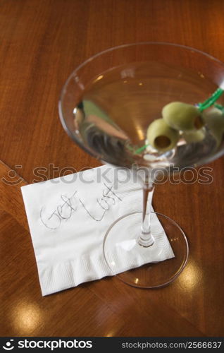 Martini and note on napkin reading oget lost.o