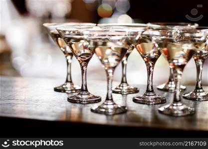martini glasses in front of gold bokeh background. Luxury cocktail drink in restaurant bar with night lights blur. Classy beverage celebration party for new year, christmas, valentine. martini glasses in front of gold bokeh background. Luxury cocktail drink in restaurant bar with night lights blur. Classy beverage celebration party for new year, christmas, valentine.