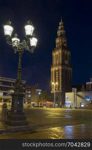 martini tower illuminated at night in dutch town of groningen in the north of the netherlands on central square
