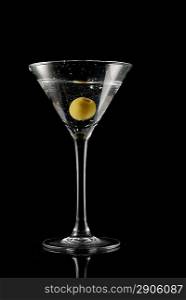 Martini with an olive on a black background