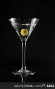 Martini with an olive on a black background