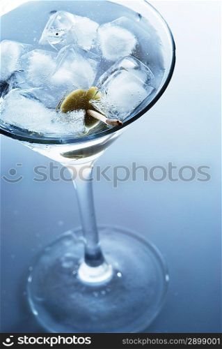 Martini with an olive on a light background