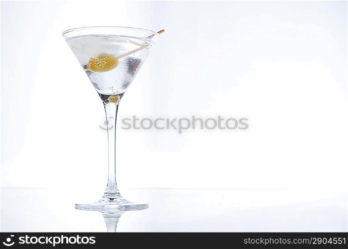 Martini with an olive on a light background