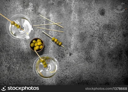 Martini with olives. On a rustic background.. Martini with olives.