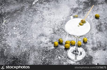 Martini with olives. On a rustic background.. Martini with olives.