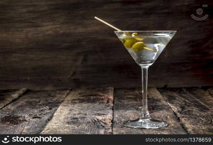 Martini with olives. On a wooden background.. Martini with olives.